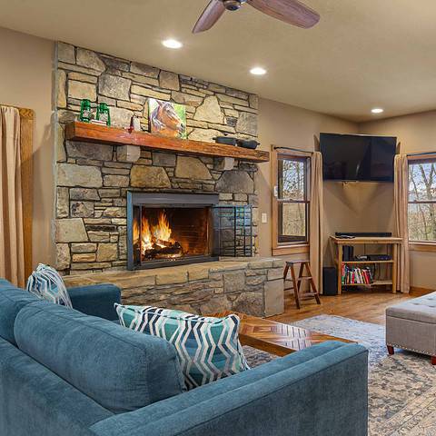 The living room has a rock fireplace.